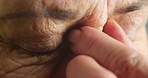 Blue eyes, stress and senior woman with headache, depression and mental health anxiety. Zoom on face vision, skin and hand of retirement elderly with burnout, looking sad and thinking about wellness