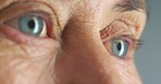 Senior woman blue eyes, lashes and wrinkle skin thinking against a studio background. Zoom in face or head of elderly woman lonely and thoughtful in retirement with light reflection in eye alone