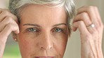 Beauty, skincare and face of elderly woman getting ready with routine grooming and hygiene in her home. Portrait, eyes and wrinkles check by mature female styling her grey hair and looking content