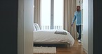 Luxury, hospitality and relax man jump on bed in hotel or home room during vacation. Happy, smile and young male tired, lazy and smile in bedroom while relaxing in apartment or house during holiday