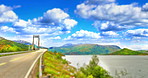 Animation of road or street with mountain, river and sky landscape with clouds in summer day. 3D graphic of nature lake along a highway street, green hills and bridge structure in the background 