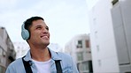 Music streaming, headphones and man listening to web radio walking in a city with a smile. Happy, relax and free time mindset of a person enjoying digital, 5g internet and online audio enjoying life