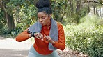 Woman checking her pulse with a smart watch while on a health, fitness and wellness run in nature. Active girl on a jog for a cardio exercise in an outdoor park with an activity tracker and towel.
