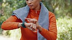 Woman fitness athlete check pulse with smartwatch while training for exercise in forest. Runner using gps tracker to monitor progress, heart rate and calories burned during workout or exercise