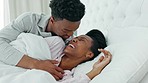 Kissing, morning and couple in bed waking up together in a luxury hotel bedroom or getaway honeymoon retreat. Love, care and happy man, woman or black people cuddle under blankets bonding on weekend