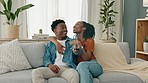 Happy black couple watching tv on the sofa together with a remote to change channel in the living room. Man and woman relax and watch movie, series or show while streaming with internet subscription