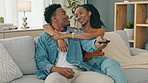 Happy, love and relax couple change channels on tv remote and watching television together on sofa at home. woman hug on man while enjoying streaming entertainment show, series and movies in house