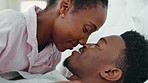 Love, smile and happy intimate couple in bed in the morning while talk and bonding together. Black man and woman relax, conversation and communication trust, support and quality time in home bedroom