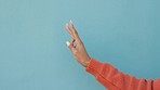 Hands, fingers and countdown with the hand of a woman doing a five count in studio against a blue background with mockup. Counting, advertising and marketing with a female against a color backdrop