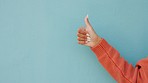 Thumbs up, like and hand emoji mockup on studio or blue wall background. Woman with yes, thank you or support sign, icon or gesture for social media review, agreement or trust with mock up