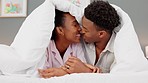 Couple, kiss and love in the bedroom while laughing and feeling happy on their honeymoon. Loving black man and woman show affection during time together to relax and enjoy a healthy marriage