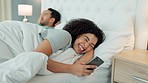 Divorce, cheating and woman texting on a phone while in bed with her husband, laughing at secret conversation. Relationship conflict and bedroom problem with toxic woman and jealous man in crisis
