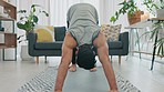 Fitness, home gym and pilates with young man workout, exercise and training in his living room. Strong, sports and health with active, yoga and motivation athlete on mat in lounge 