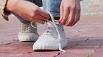 Hands tying sneakers shoes laces on feet in city street, casual fashion and urban road style outdoors. Trendy walking woman, prepare strings ready and comfortable fitting footwear on cool sidewalk