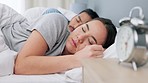 Couple, sleep and alarm clock in bedroom with wake up  sound makes annoying noise in the morning. Tired, exhausted and drained people decide to ignore the time and relax in bed together.