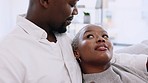 Black couple, love and relaxing at home with conversation, talking and bonding for quality time, relaxing and carefree fun together. Happy african people in cuddle, romance and relationship on couch
