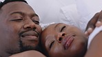 Black couple, bedroom love and home relaxing in cuddle, talking and bonding for quality time, conversation and carefree romance together. Happy african people, lying bed and comfortable relationship