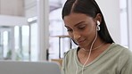 Student, study and learning on laptop while listening to podcast or music with earphones in home. Indian woman studying for school, college or university while typing a project online before deadline