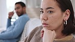 Asian couple, woman or divorce fight in house living room, sofa or home interior. Zoom on sad woman face, depression or anxiety over cheating affair argument with man or boyfriend in marriage therapy