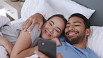 Social media, bed and laugh with a young couple lying in their bedroom and looking at a meme or joke online. Married man and woman browsing the internet on a phone with wifi and wireless technology