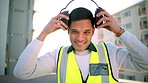 Building construction, man and safety ear headphones for happy, smile and motivation worker or engineering employee. Portrait of industrial architect with property vision for real estate architecture