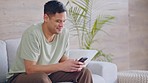 Streaming, social media and happy man texting on a phone while relax on a sofa at home in living room. cheerful male enjoying the weekend indoors, chatting on online app or checking a dating website