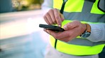 Phone, hands and communication with an engineer, construction worker or building planner working in his office. Building manager reading a text message on a mobile smartphone while outside on a site
