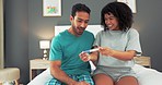 Black couple celebrate positive pregnant test result and amazing, surprise and wow baby news in bedroom at house. Happy black woman smile with child pregnancy success surprise announcement  for man