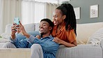 Couple phone selfie, funny communication and relax on sofa in house, comic conversation with social media on smartphone and comedy talking on web. Happy African man and woman taking photo with tech