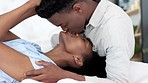 Black man and black woman couple kiss. Young, in love and African American people in relationship saying I love you. Kissing, romantic and smiling face to face in bed together at home, intimacy
