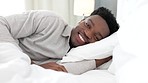 Sleep, bed and man portrait in bedroom at a luxury hotel for vacation or holiday home in the morning. Smile of a black man lying on pillow for comfortable furniture, bedding or new apartment 