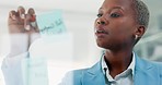 Mindmap, sticky notes and black woman writing a strategy on glass wall or transparent board for a company. Businesswoman planning, brainstorming and working on a creative marketing idea in an office