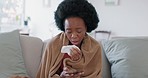 Sick, sneeze and phone with black woman using tissue on sofa and texting on her phone for medical, healthcare or illness. Virus, allergy or cold with young female with blanket in living room at home