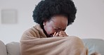 Sad crying black woman with depression at home on couch, sofa or living room mourning the loss of a loved one. Anxiety, stress and tears of African female with poor mental health after physical abuse