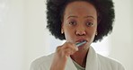 Dental, health and black woman brushing teeth in bathroom interior at home in the morning. Oral healthcare, hygiene and fresh breath with toothpaste, toothbrush and water for wellness and white teeth