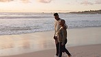 Beach, couple and sunset walking on the beach together on summer vacation. African american boyfriend and girlfriend relax, freedom and romance at the seaside while talking on honeymoon holiday