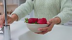 Hands of woman cleaning strawberry with water for body health, nutrition and wellness. Food, fruit and nutritionist girl washing healthy and organic strawberries for clean eating and diet in kitchen