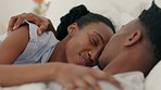 Love, hug and kiss bedroom black couple relaxing at home for romance, bonding together and intimacy. Happy, valentines day and smile young african people in flirting relationship on special honeymoon