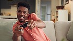 Internet, streaming and online gamer playing video game and sitting on a sofa in living room, excited and energy. Black man enjoying freedom and day off with home entertainment and new subscription 