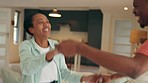 Happy young couple dance to music together at home, they joke as they smile and laugh in love at room new house. Black couple celebrate new milestone in their relationship, dancing playfully and hug 