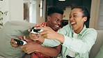 Holding, laughing and pressing playstation controllers. A young, happy attractive black couple chilling on the sofa at home playing and having fun. A smiling man and woman spending time indoors