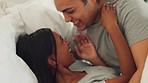 Love, kiss and couple play in bed together while relax in hotel bedroom on marriage honeymoon vacation. Diversity, romance and happy man and woman have fun, bonding and enjoy quality time on holiday