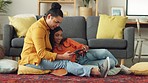 Interracial couple on social media with digital tablet in the living room while bonding together. Man and woman sitting on the floor reading funny or comedy post online the internet or web at home