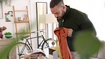 Living room, laundry and man with clean clothes busy with basket organisation in home. Young male with tidy house lifestyle habit sorting wardrobe shirt clothing garments into stack order.