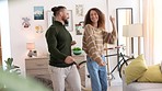 Dancing couple, fun and energy while doing a groovy dance to celebrate good news or anniversary in living room at home. Playful man and woman feeling happy and having fun together during free time