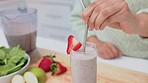 Health, kitchen and woman with smoothie drink for healthy lifestyle, nutrition or wellness while relax at home. Young nutritionist vegan girl stir fruit, strawberry or apple milkshake for weight loss