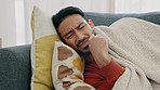 Sick, tired and sad man lying on sofa at home feeling ill, unhappy or depressed thinking about problems, grief or sorrow. Anxiety, depression and mental health of asian male crying over heartbreak