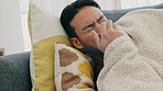 Allergy, covid and sick man on home sofa with with cold, flu or sinus problem. Young person on living room couch with tissue and nose or nasal healthcare for healthcare insurance or corona virus