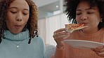 Women friends eating pizza on sofa in their home apartment and happy with fast food  Hungry young, gen z black people or lesbian couple with lunch enjoying meal together in their lounge on the couch