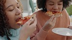 Pizza, fast food and friends with a girl and her friend eating and laughing together in their home. Biting, hungry and snack with an attractive young woman and sister enjoying a meal in their house